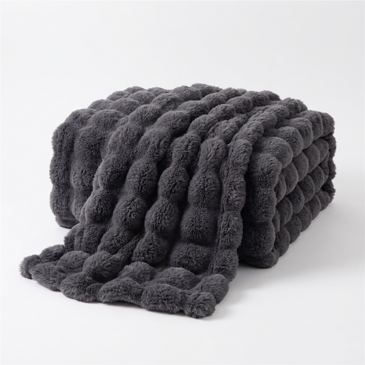 Opgevouwen donkergrijze plaid met pluizige bubbelstructuur op een witte achtergrond 14