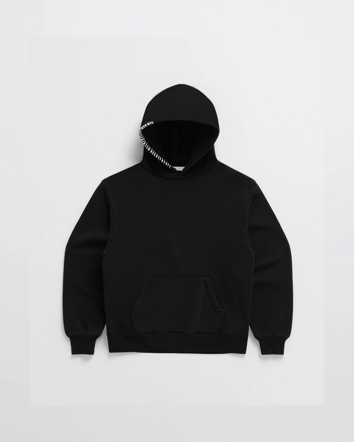 Zwarte hoodie van voren, met witte stiksels langs de capuchonrand die duidelijk afsteken, plus buidelzak en geribbelde boorden. 5