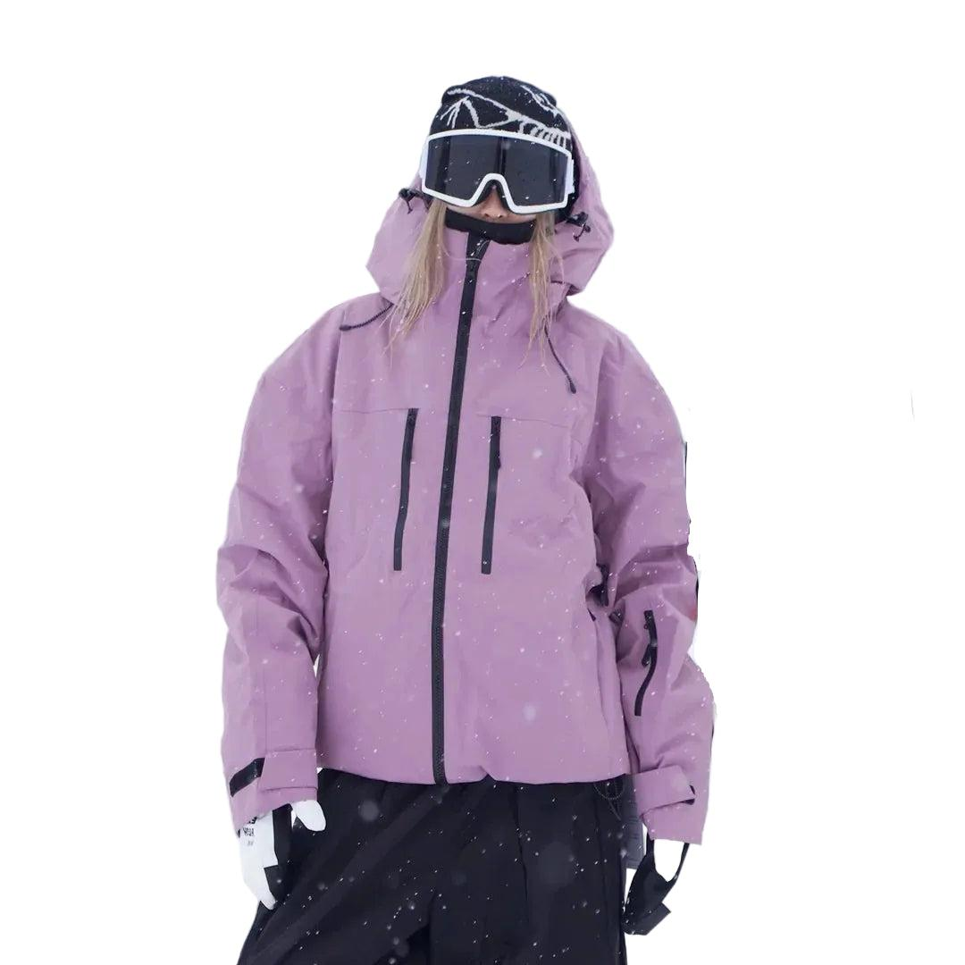 Model in roze-paarse sneeuwjack met capuchon, frontaal gefotografeerd, met ritszakken op de borst en een zakje op de mouw. 4