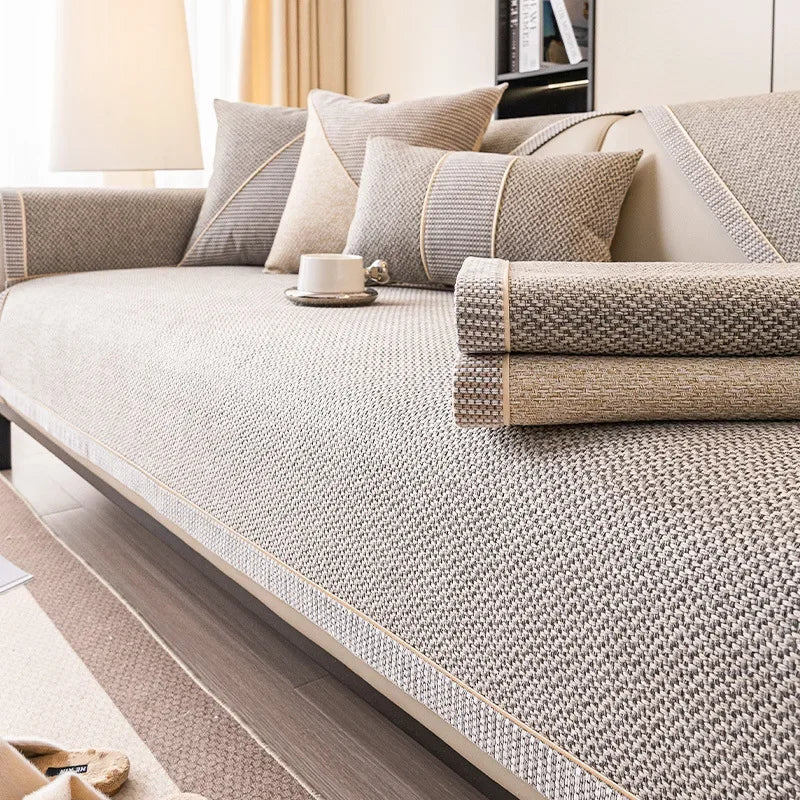 Taupe bankhoes met twee opgerolde stukken stof op de zitting, in een grijze en een beige variant. 6