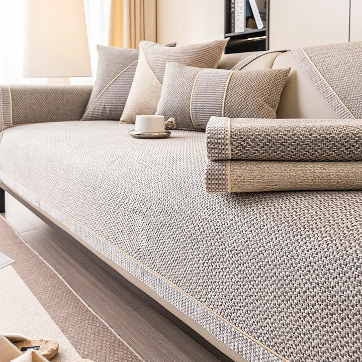 Taupe bankhoes met twee opgerolde stukken stof op de zitting, in een grijze en een beige variant. 6
