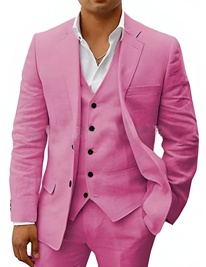 Model draagt het pak in roze, driedelig met jasje, gilet en broek, wit overhemd eronder. 14