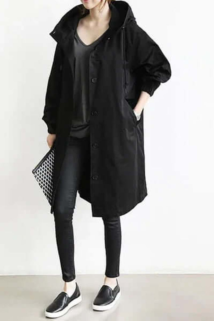 Zwarte lange jas met capuchon over zwarte kleding, gedragen met geruite clutch en instappers 3