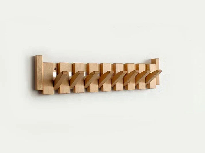Lichte houten wandhanger met alle haken schuin uitgeklapt, tegen een witte muur 8