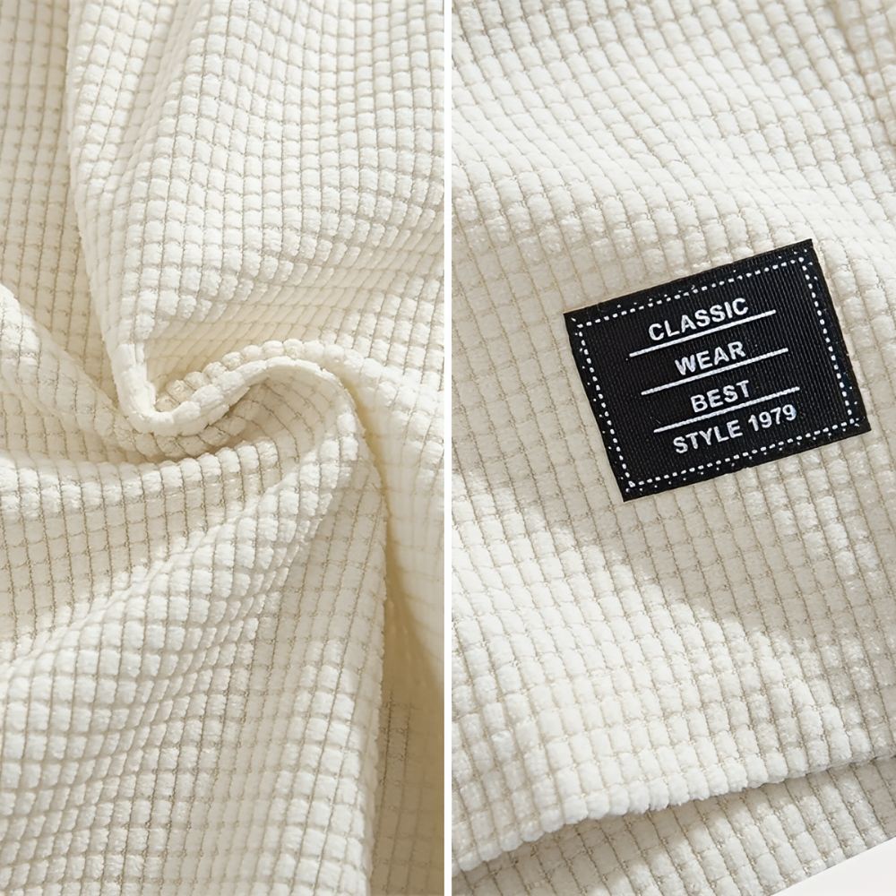 Twee detailbeelden van de crèmekleurige wafelstof: links de gedraaide stof met reliëf, rechts het zwarte label op de pijp. 9