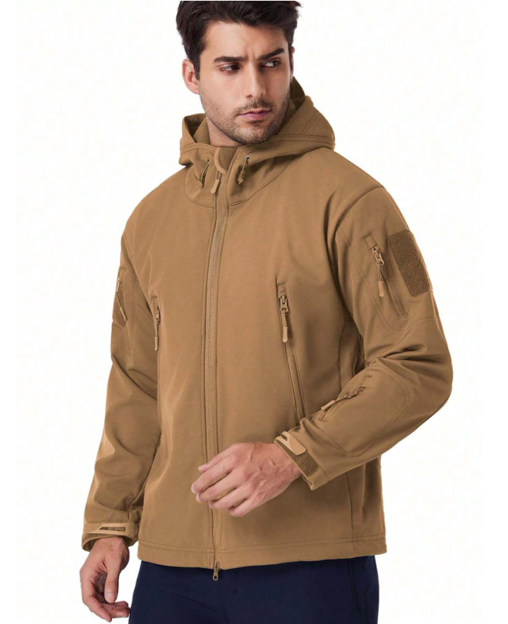 Man draagt de beige jas met capuchon, vooraanzicht met ritszakken en klittenbandvlak op de mouw. 16